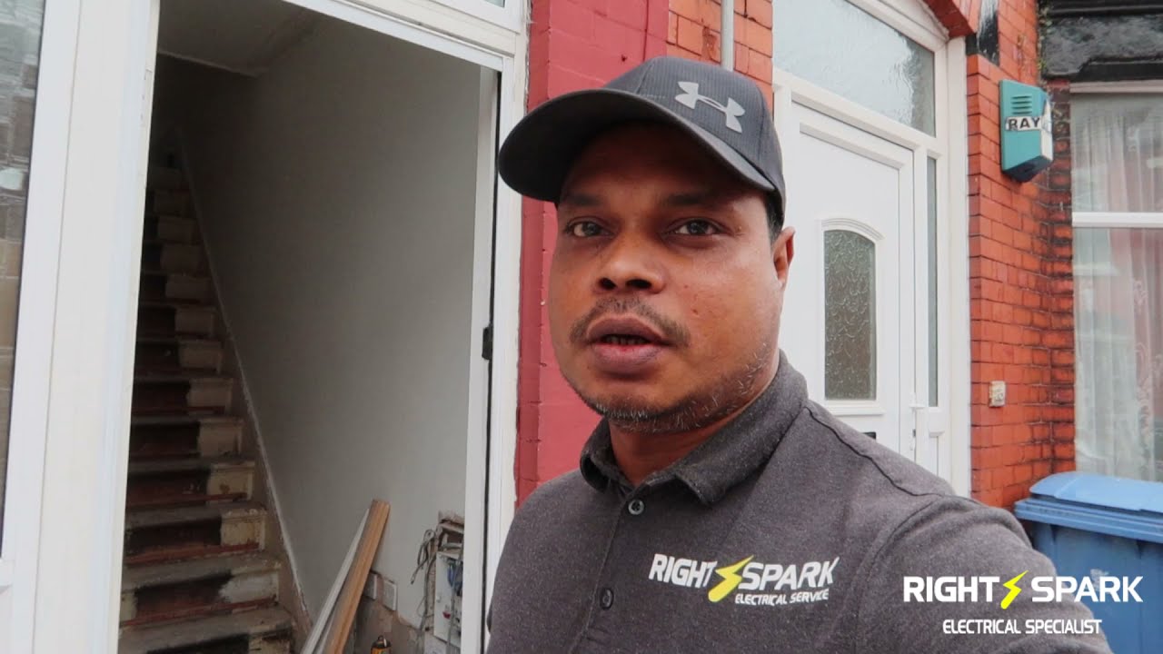 Naz in a Right Spark top and cap, standing outside a terraced house
